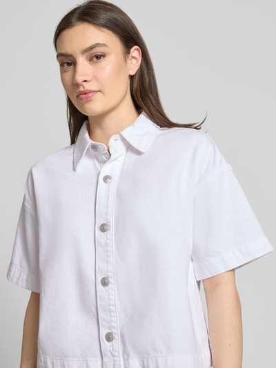 Frauenmodel trägt Loose Fit Jeansbluse aus reiner Baumwolle Modell 'SKY' von Pieces in Weiß, kurzarm, Hemdkragen, Nahaufnahme Oberkörper.