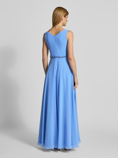Modelka kobieca nosi sukienka wieczorowa 'Abendkleid mit V-Ausschnitt und Perlenbesatz' od Vera Mont z szyfonu, linia a, długa sukienka, dekolt w serek, szerokie ramiączka, marszczenia, obszycie perłami, zamek błyskawiczny z tyłu, długość tyłu w rozmiarze 38: 140 cm, szerokość w rozmiarze 38: 38 cm, widok całej sylwetki z tyłu.
