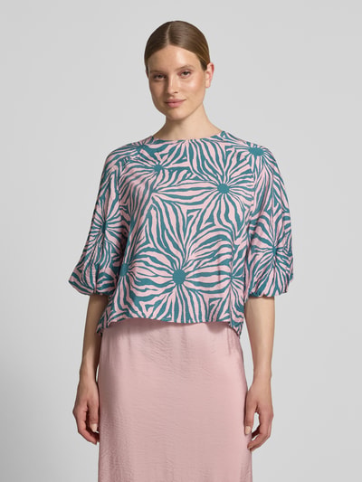 Frauenmodel trägt Regular Fit Bluse aus Viskose-Mix im Allover-Look von Christian Berg Woman in Rosa und Blau, Rundhalsausschnitt, 3/4-Arm, Ganzkörperansicht von vorne.