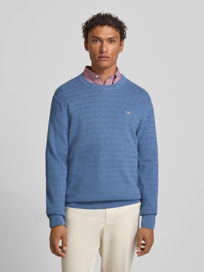 Męskimodel nosi Sweter z dzianiny z fakturowanym wzorem i wyhaftowanym logo Strickpullover mit Strukturmuster und Label-Stitching od Gant, bawełna, krój regular fit, okrągły dekolt, długość tyłu 71 cm, długość rękawów 68 cm; widok całej sylwetki z przodu.