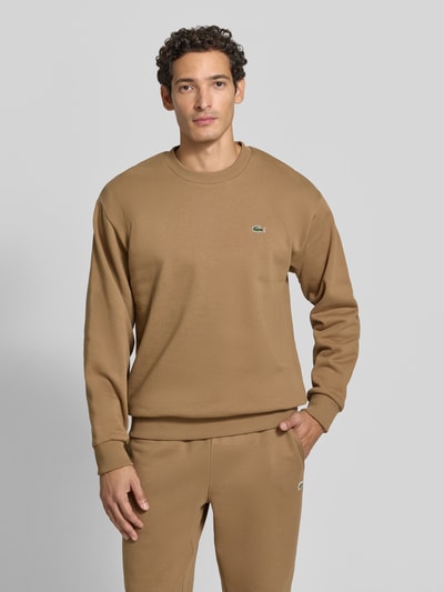 Männermodel trägt Regular Fit Sweatshirt aus Baumwoll-Mix von Lacoste in Braun, glatte Textur, Ganzkörperansicht von vorne, Herren Sweatshirt von Lacoste.