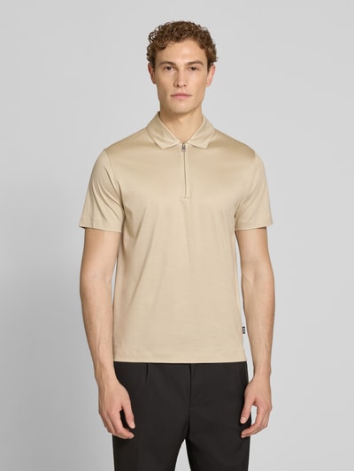 Männermodel trägt Regular Fit Poloshirt aus Lyocell-Baumwoll-Mix Modell 'H-PARAS 50' von BOSS in Beige, unifarben, Ganzkörperansicht von vorne.