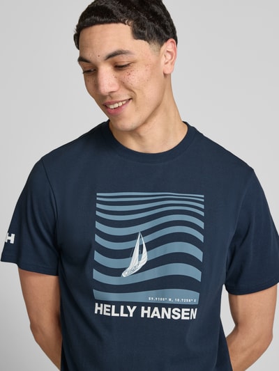 Männermodel trägt Herren T-Shirt mit Logo-Motiv-Print Modell 'SHORELINE' von Helly Hansen, Reine Baumwolle, Gerader-Schnitt, Rundhalsausschnitt, Nahaufnahme Oberkörper.