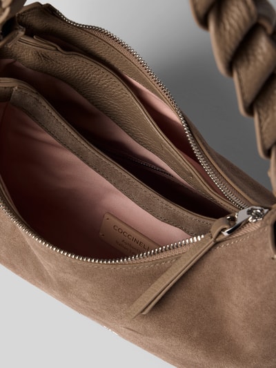 Produktfoto, Handtasche mit Logo-Detail Modell 'Boheme' von Coccinelle aus braunem Veloursleder, geteiltes Hauptfach mit Reißverschluss, geflochtener Trageriemen, Innenfutter in Rosa, Größe 28x22x11 cm, Schulterriemen 54 cm.