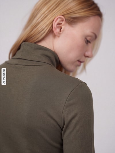 Frauenmodel trägt Regular Fit Langarmshirt aus reiner Baumwolle von s.Oliver RED LABEL in Olivgrün mit feiner Stoffstruktur, Nahaufnahme Rückenansicht, KI-modifiziertes Bild.