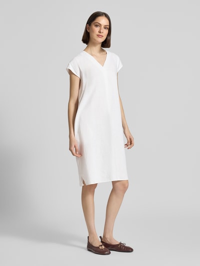 Frauenmodel trägt knielanges Leinenkleid mit V-Ausschnitt Modell 'Ina' von Soyaconcept im Loose-Fit, Leinen-Mix, helle Farbe, Seitliche Schlitze, Ganzkörperansicht von vorne.