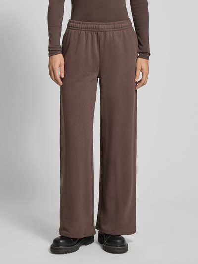 Frauenmodel trägt Wide Fit Sweatpants mit elastische Bund von Gina Tricot aus Baumwoll-Mix, Relaxed-Fit, braun, Ganzkörperansicht von vorne.