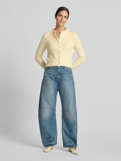 Vrouwenmodel draagt gebreid jack met ronde hals, regular fit, knoopsluiting, Model 'GLENNA' van DRYKORN, ruglengte maat S 52 cm, mouwlengte 68 cm, lichte jeans, zachte textuur, Ganzkörperansicht von voren.