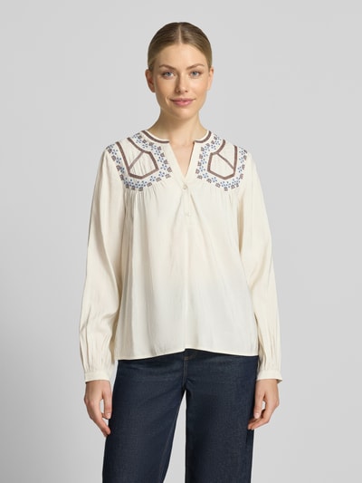 Frauenmodel trägt Bluse aus Viskose-Mix mit kurzer Knopfleiste Modell 'IRISA' von b.young, cremefarben mit braunen Details, Regular Fit, Serafino-Ausschnitt, Ganzkörperansicht von vorne. Rückenlänge 62 cm, Ärmellänge 63 cm.