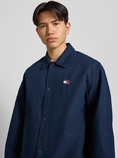 Männermodel trägt Regular Fit Hemdjacke aus reiner Baumwolle von Tommy Jeans, Optik: Unifarben, Langarm, Nahaufnahme Oberkörper.