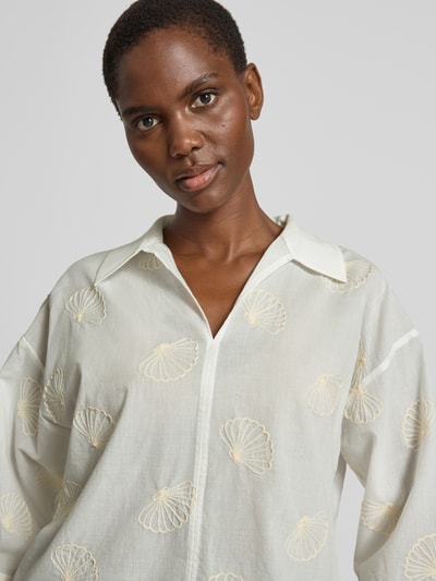 Vrouwenmodel draagt Boxy Fit Bluse mit Stitchings Modell 'Famoni' van OPUS, katoenmix, hemdblousekraag, V-hals, gebroken witte kleur, schelpvormige stiksels, detailopname bovenlichaam.