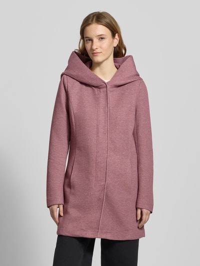 Frauenmodel trägt taillierten Mantel mit Kapuze Modell 'SEDONA' von Only, aus melangefarbenem Stoff mit verdecktem Verschluss und Eingrifftaschen, Nahaufnahme Oberkörper.