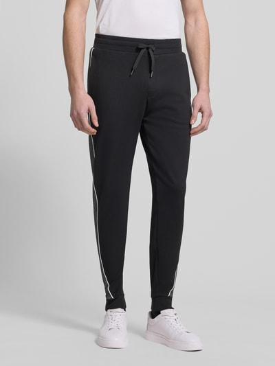 Männermodel trägt Regular Fit Sweatpants aus Baumwoll-Mix von BOSS, Optik: Unifarben, mit Galonstreifen und Label-Applikation aus Metall, elastischer Bundabschluss, Beinabschluss gerippt, seitliche Eingrifftaschen, Materialverarbeitung: Sweat, Ganzkörperansicht von vorne.