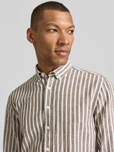 Männermodel trägt Relaxed Fit Freizeithemd mit Button-Down-Kragen von Lindbergh aus Leinen-Baumwoll-Mix, Nahaufnahme Oberkörper. Rückenlänge 64 cm, Schulterbreite 41 cm, Ärmellänge 64 cm, Knopfleiste, Sportmanschetten, Größe M.