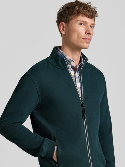 Męski model nosi Regular Fit Jacke aus Baumwoll-Mix Modell 'SELANIK' od LERROS, kolor zielony, detaliczne faktury, zamek błyskawiczny, kieszenie boczne, długość tyłu w rozmiarze M: 69 cm, długość rękawa w rozmiarze M: 65 cm, zdjęcie z przodu, zbliżenie na górną część ciała.