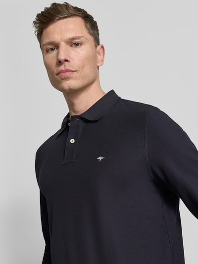 Männermodel trägt Poloshirt mit Label-Stitching von Fynch-Hatton in Dunkelblau, Reine Baumwolle, Regular-Fit, Nahaufnahme Oberkörper.