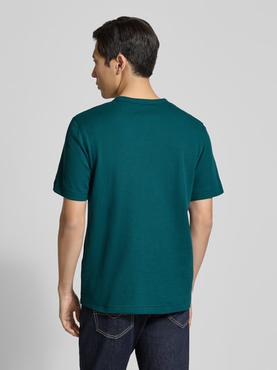 Männermodel trägt Regular Fit T-Shirt aus Baumwoll-Mix von Tom Tailor in Uni-Optik, Label Patch, grün, kurzarm, Rückansicht, Ganzkörperansicht