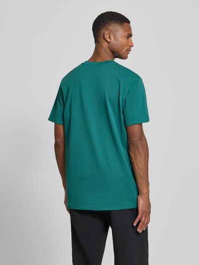 Männermodel trägt Regular Fit T-Shirt mit Logo-Applikation von Under Armour, grün, Baumwoll-Mix, Rückenansicht, Ganzkörperansicht Rückansicht.