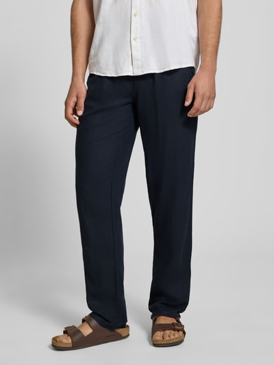 Männermodel trägt Wide Fit Leinenhose mit Viskose-Anteil Modell 'Malvin' von Blend in Dunkelblau, elastischer Bund, Nahaufnahme Unterkörper, Vorderansicht.