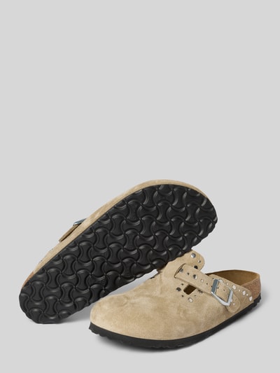 Produktfoto, Hausschuhe aus echtem Veloursleder Modell 'Boston Rivet' von Birkenstock in Beige mit Zierschnalle, Ziernieten und abgerundeter Passform, Absatzhöhe 3 cm, Schaftweite 7 cm, gröberer Struktur und schwarzer Laufsohle vor grauem Hintergrund.