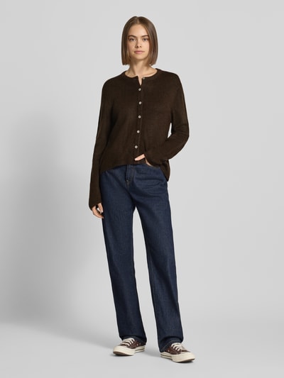Frauenmodel trägt Loose Fit Strickjacke mit Rundhalsausschnitt Modell 'SIMONI' von ONLY in Dunkelbraun, kombiniert mit blauer Jeans, Damen Strickjacke von ONLY, Ganzkörperansicht von vorne.