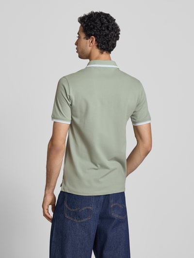 Männermodel trägt Slim Fit Poloshirt mit Logo-Stitching Modell 'Reed' von SERGIO TACCHINI in Grün, Baumwoll-Mix, Ganzkörperansicht Rückansicht.
