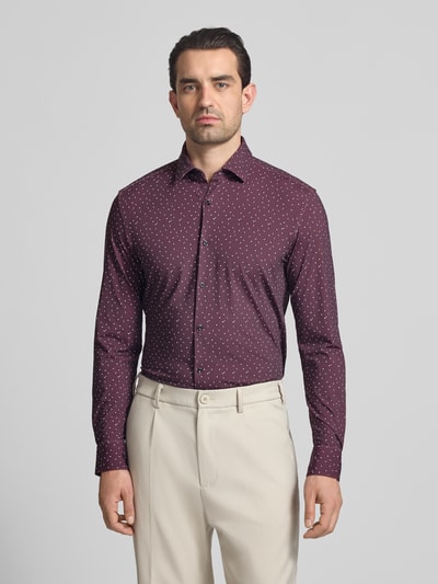 Männermodel trägt Slim Fit Businesshemd mit Kentkragen Modell 'KENNO' von HUGO, Optik:Allover-Muster, Label-Stitching, Ganzkörperansicht von vorne.
