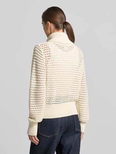 Frauenmodel trägt Regular Fit Cardigan aus reiner Baumwolle Modell 'Eloise' von VARLEY in Strick-Optik, Cremefarbe, Ganzkörperansicht Rückansicht. Rückenlänge und Ärmellänge passend für Größe S, Umlegekragen, sichtbarer Reißverschluss.