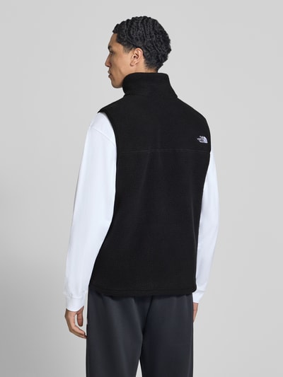 Männermodel trägt Regular Fit Weste mit Logo-Stitching Modell 'Yumiori' von The North Face in Schwarz, Fleece, Ganzkörperansicht Rückansicht. Rückenlänge 67 cm, Schulterbreite 41 cm, Brustweite 56 cm, Stehkragen, Napoleontasche, Eingrifftaschen.