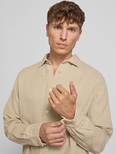 Männermodel trägt Regular Fit Freizeithemd mit Kentkragen von Lindbergh in Beige aus Reine Baumwolle, Langärmelig, Nahaufnahme Oberkörper. Rückenlänge bei Größe M: 73 cm, Schulterbreite: 47 cm, Ärmellänge: 67 cm, Knopfleiste.