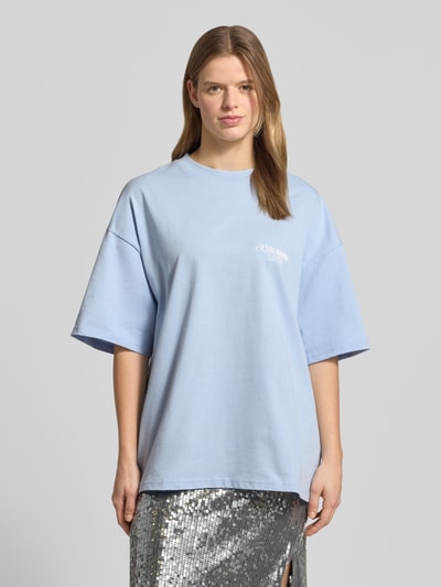 Frauenmodel trägt Oversized T-Shirt mit rückseitigem Statement-Print von Karo Kauer in Hellblau aus Reine Baumwolle, Oversized-Fit, Rundhalsausschnitt, überschnittene Schultern, Label-Print, Rückenlänge bei Größe S: 71 cm, Ganzkörperansicht von vorne.