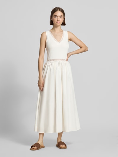 Frauenmodel trägt weißes Midikleid mit Spitze Modell 'Nami' von OH APRIL aus Baumwoll-Viskose-Mix, Taillierter Schnitt, Ganzkörperansicht von vorne.
