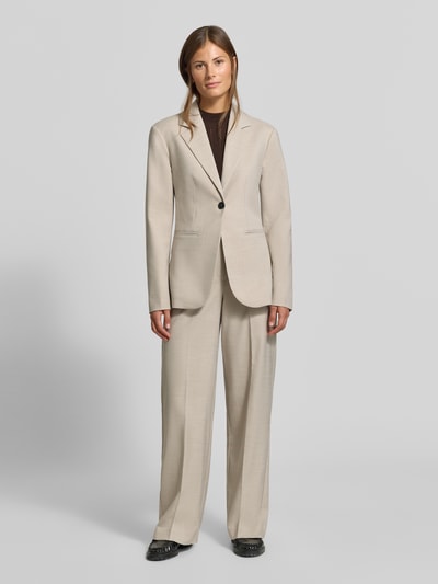 Frauenmodel trägt Slim Fit Anzugblazer mit Viskose-Anteil von MYON in Beige, Reverskragen, Knopfverschluss, Ganzkörperansicht von vorne. Material-Mix, seitliche Paspeltaschen, Rückenlänge 70 cm, Brustweite 47 cm, Ärmellänge 64 cm.