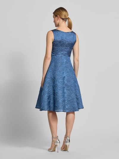 Frauenmodel trägt Cocktailkleid mit Strukturmuster und V-Ausschnitt von Vera Mont in Blau, A-Linie, Midikleid, Ganzkörperansicht Rückansicht.