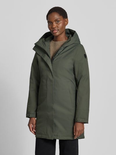 Frauenmodel trägt Parka mit 10.0000mm Wassersäule von G.I.G.A. DX in Olivgrün, verdeckter Reißverschluss, Ganzkörperansicht von vorne. Regular Fit, Kapuze, Eingrifftaschen, Ärmelriegel, Rückenlänge 88 cm, Schulterbreite 42 cm, Brustweite 49 cm, Ärmellänge 64 cm.