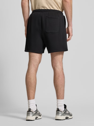 Mężczyznamodel nosi Regular Fit Shorts aus Baumwoll-Mix von Tommy Jeans, efekt: jednolity kolor, detal z logo marki, tunel, krój regular fit, dzianina dresowa, mieszanka bawełny, kieszeń z tyłu, wpuszczane kieszenie, elastyczny ściągacz, zapięcie tunel Ganzkörperansicht Rückansicht