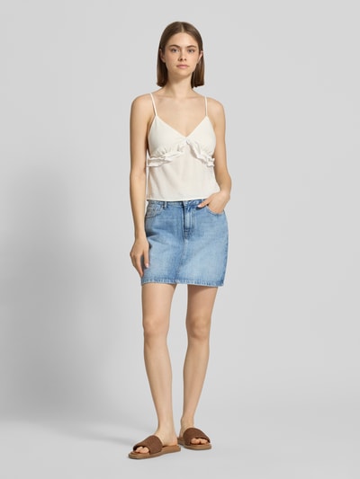 Frauenmodel trägt eng anliegenden Jeansrock aus Bio-Baumwoll-Mix Modell 'STELLA' von Only im Denim-Look, Mini-Länge, 5-Pocket-Design, Label-Patch, Knopf und verdeckter Reißverschluss, Gürtelschlaufen, hellblaue Farbe, glatte Textur, Ganzkörperansicht von vorne.