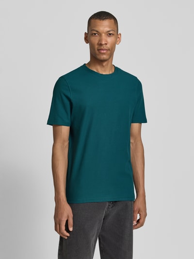 Męski model nosi T-Shirt mit Rundhalsausschnitt od MCNEAL, czysta bawełna, krój slim fit, ciemnozielony kolor, widok całej sylwetki z przodu, długość tyłu w rozmiarze M: 68 cm.