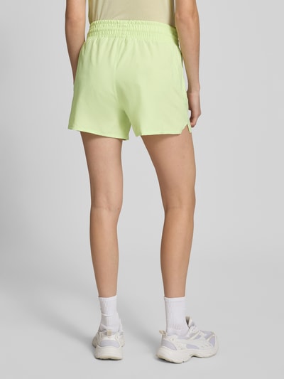 Frauenmodel trägt Regular Fit Shorts mit elastischem Bund Modell 'Kout' von Salomon in Hellgrün, strukturierte Oberfläche, Bundweite 36 cm, Innenbeinlänge 10 cm, Integrierter Slip, Ganzkörperansicht Rückansicht.