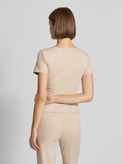 Frauenmodel trägt Slim Fit T-Shirt mit Karree-Ausschnitt Modell 'Kalina' von OH APRIL, beigefarbener Lyocell-Elasthan-Mix, Ganzkörperansicht Rückansicht.