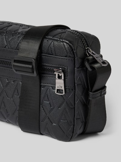 Produktfoto, schwarze Handtasche mit Logo-Muster von ARMANI EXCHANGE, Außentasche, Reißverschlüsse, Schulterriemen, Nahaufnahme Detail.