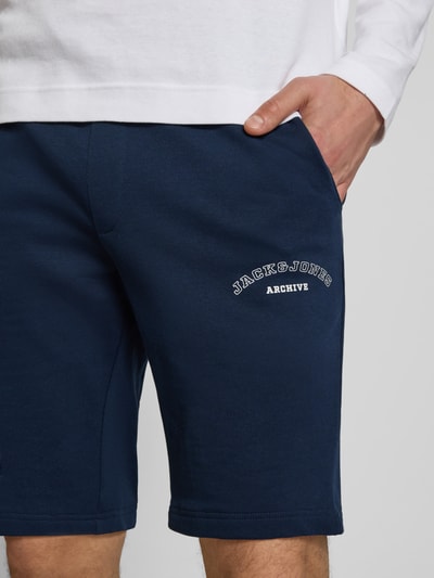 Männermodel trägt Shorts mit Logo-Print Modell 'GORDON' von Jack & Jones in Dunkelblau, Baumwoll-Mix, Nahaufnahme Oberschenkel.
