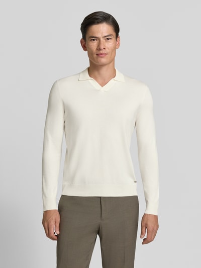 Männermodel trägt cremefarbenen Strickpullover mit Viskose-Anteil Modell 'MANICA LUNGA' von MARKUP, gerader Schnitt, Umlegekragen, Ganzkörperansicht von vorne.