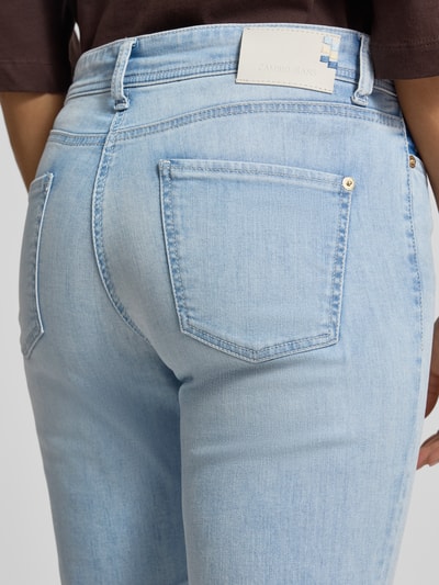 Frauenmodel trägt Tapered Fit Jeans aus Baumwoll-Mix Modell 'PIPER' von Cambio in hellblau mit glatter Textur, Nahaufnahme Rückansicht, Damen Tapered Fit Jeans von Cambio.