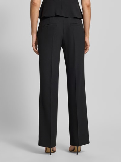 Frauenmodel trägt Straight Fit Hose mit Bundfalten von HUGO, Optik: Unifarben, Passform: Straight, Ganzkörperansicht Rückansicht.