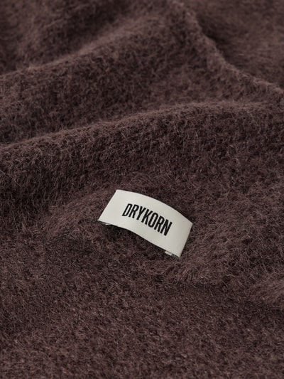 Produktfoto, Dreieckstuch mit Woll-Anteil von DRYKORN in Braun, Strick-Optik, weiche Textur, Label-Patch, Detailaufnahme. Material-Mix, eingefasste Abschlüsse, Breite bei Größe 1: 58 cm.
