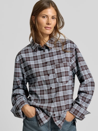 Frauenmodel trägt Regular Fit Hemdbluse mit Viskose-Anteil von MYON, kariertes Muster in Braun und Blau, Brusttasche, Nahaufnahme Oberkörper. Elastischer Material-Mix, Hemdblusenkragen, langärmelig, Knopfleiste.