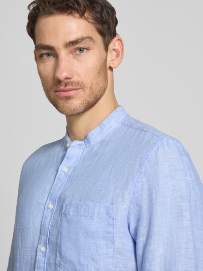 Männermodel trägt Slim Fit Leinenhemd mit Stehkragen Modell 'Mandarin' von SEIDENSTICKER, hellblau, Brusttasche, Nahaufnahme Oberkörper.