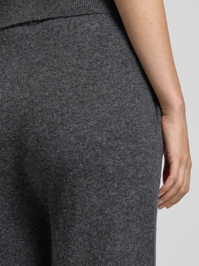 Frauenmodel trägt Hose aus Lanawoll-Mix mit Kaschmir-Anteil Modell 'LOTTIMO' von MM by Max Mara, meliertes Dunkelgrau, weiche Textur, Nahaufnahme Hüfte, Straight Fit, elastischer Bund, KI-modifiziertes Bild.