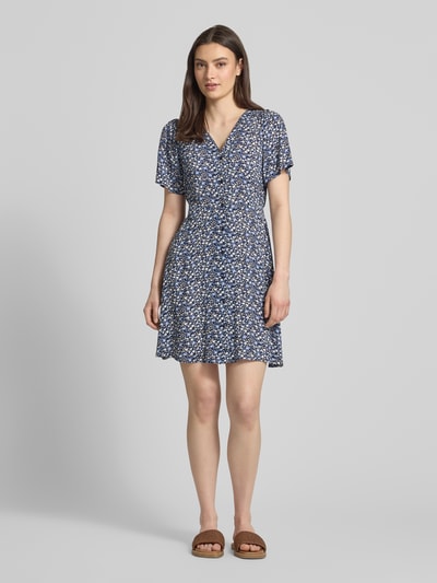 Frauenmodel trägt Minikleid aus reiner Viskose Modell 'EVIDA' von Only mit Allover-Muster, tailliert, kurzarm, Ganzkörperansicht von vorne.
